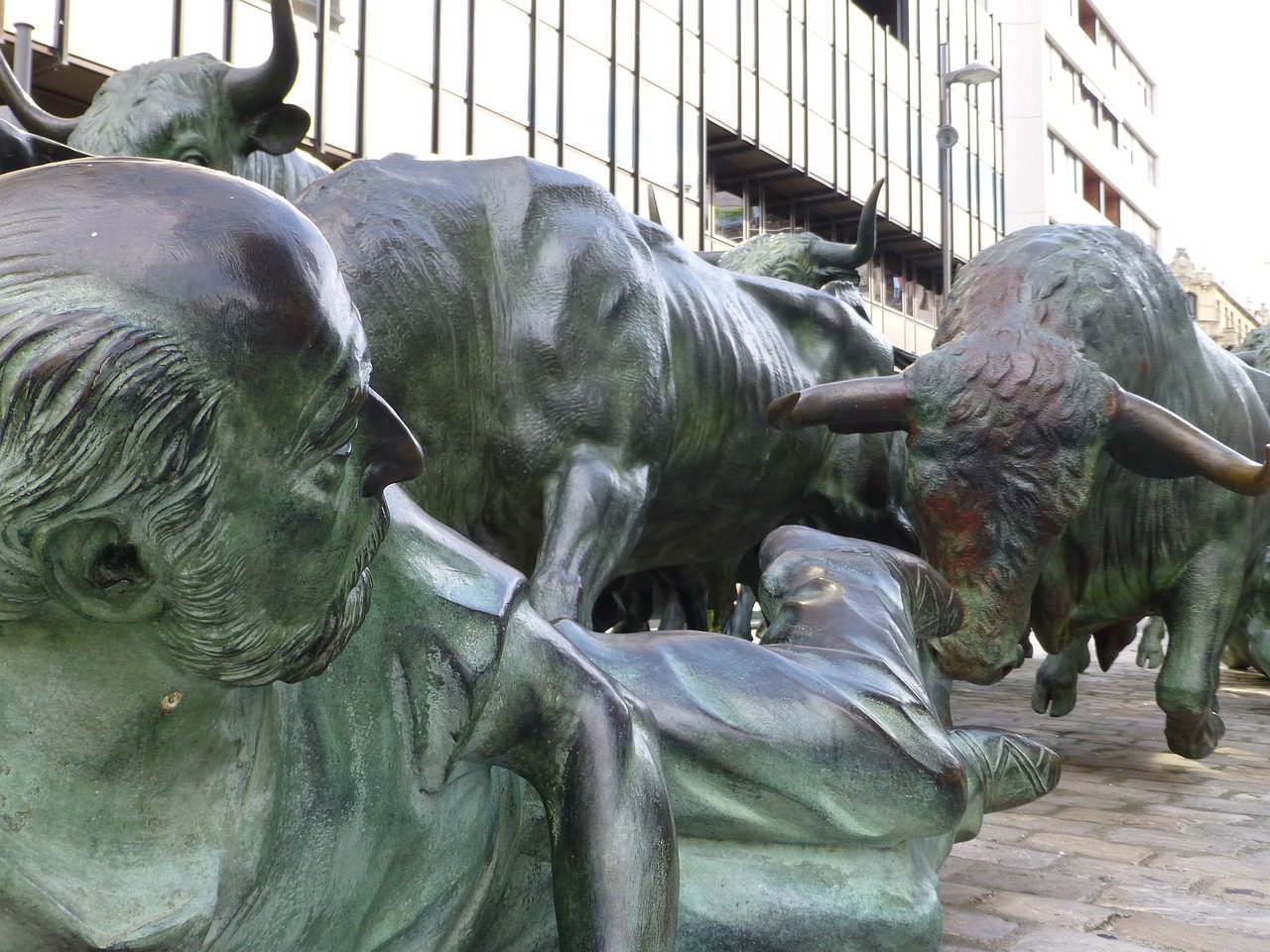 Bronze monument to the encierro in Pamplona showing bulls charging past runners